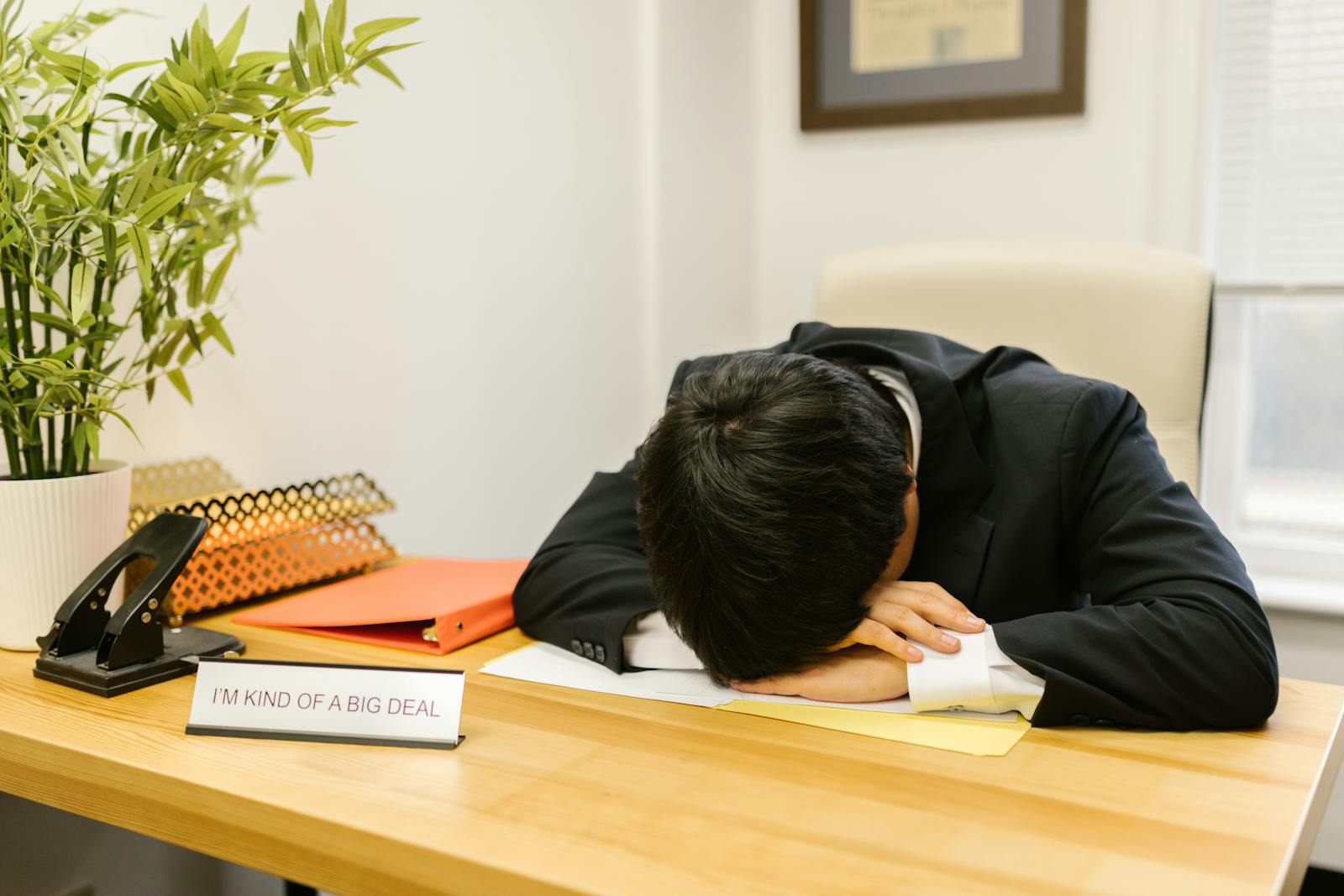 A Man in a Suit Sleeping on the Desk